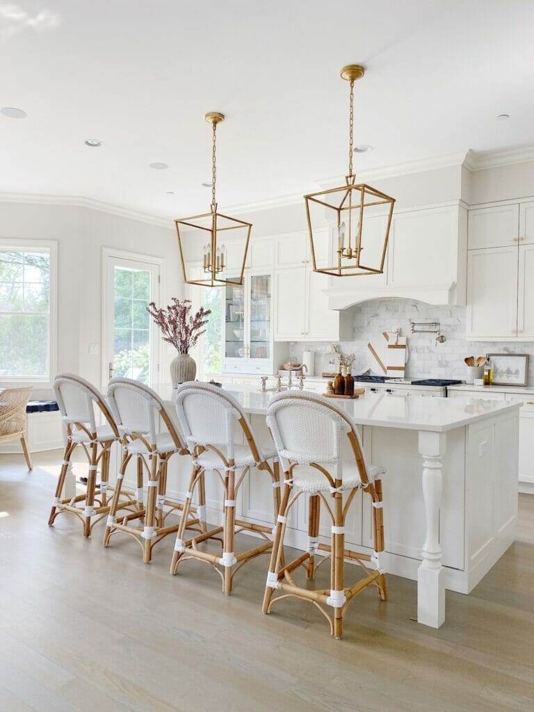 Style a white kitchen island with serena and lily riviera counter stools and hanging lanterns